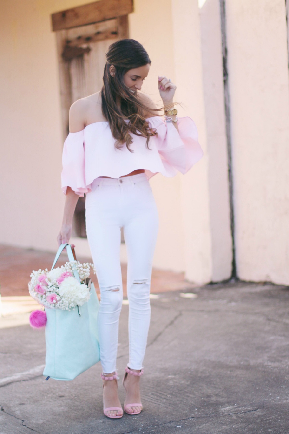 Thalia pink off the shoulder crop top with white ripped jeans and mint vegan leather bag